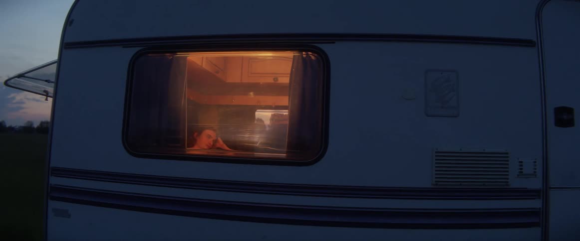 A man sits in a camper parked in the outdoors