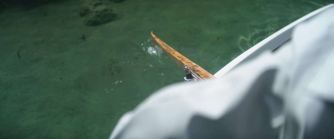 Someone is rowing a boat and the paddle is moving in and out of the water