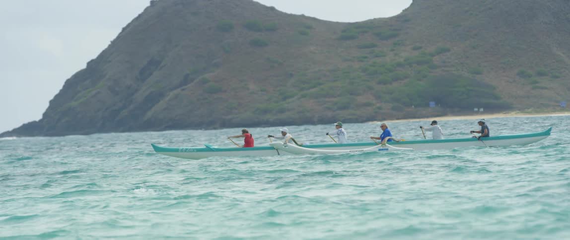 People canoeing in choppy teal blue water