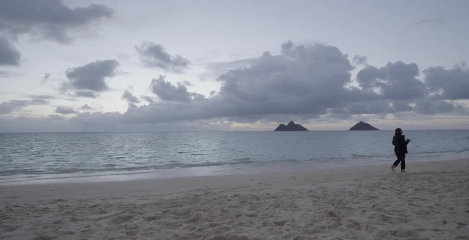 A woman walks across the beach