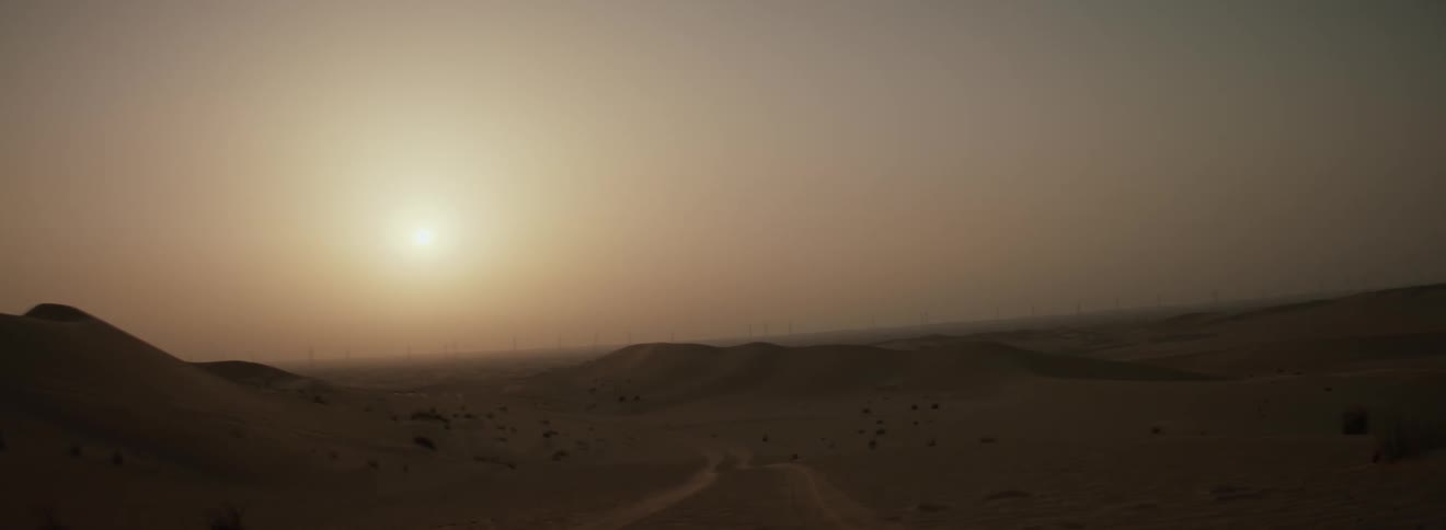 The sun is rising on the desert
