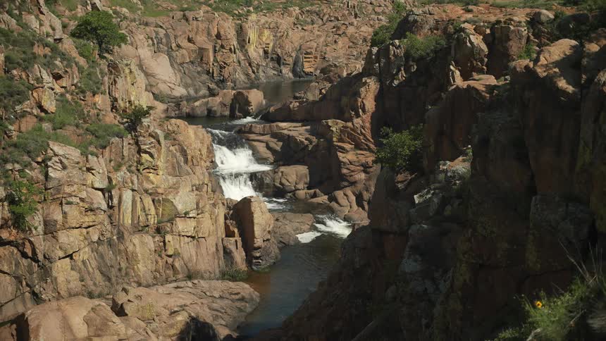 The stream is running downhill past the rocks