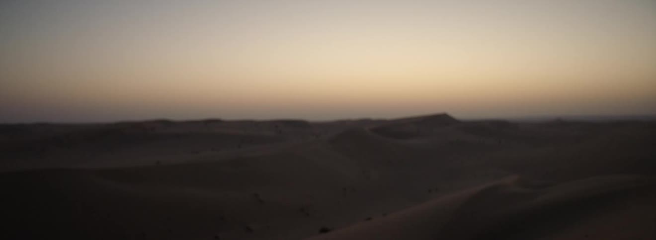 Drifted sand dunes across a desert slowly come into focus