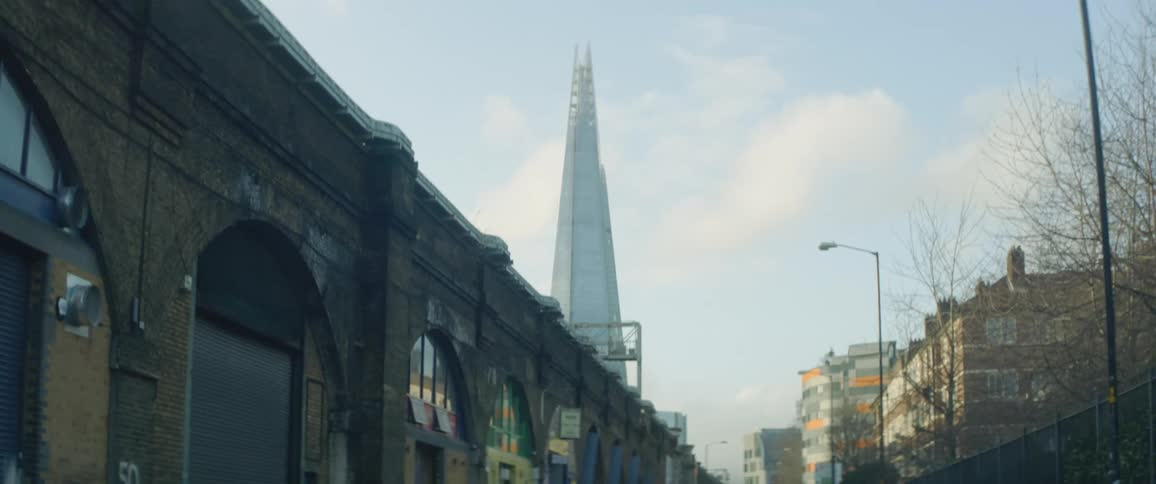 Low buildings are towered over by tall skyscraper with pyramidal architecture