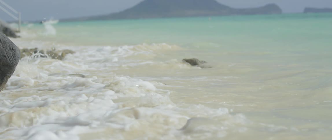 Waves crash over rocks on a beach