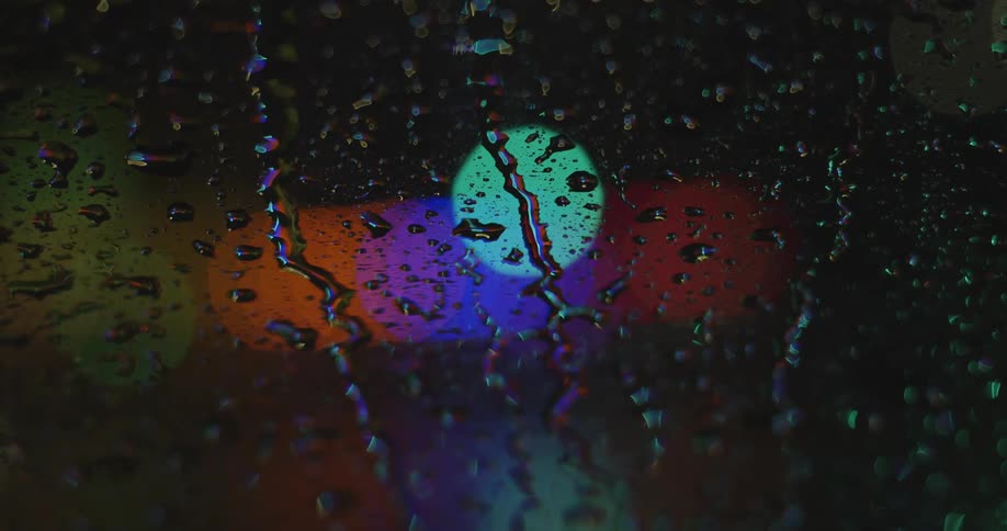 Rain is creating drops on a window that are running down