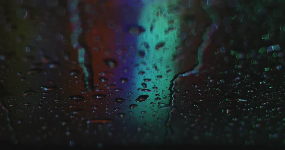 Raindrops on glass with lights in the background