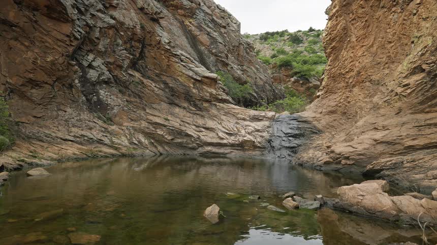 A shallow rock filled river in a mountain canyon