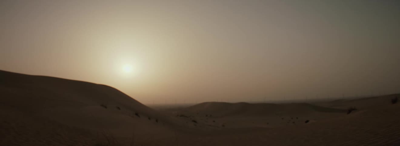 The sun is rising on the desert