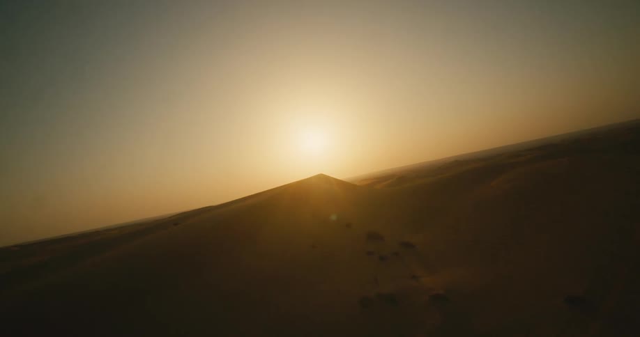 The sun is rising on the desert