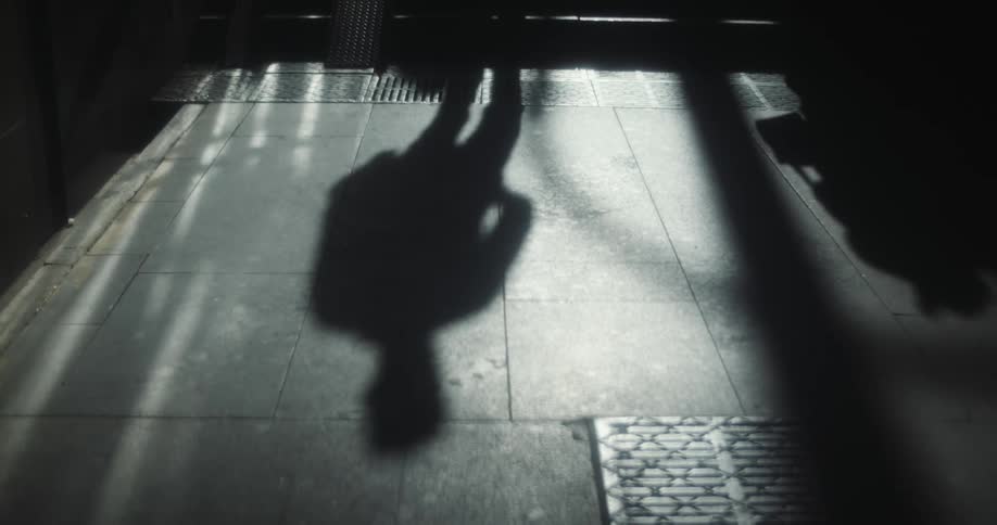 Peoples shadows reflected on ground when going up and down the dark underground stairs