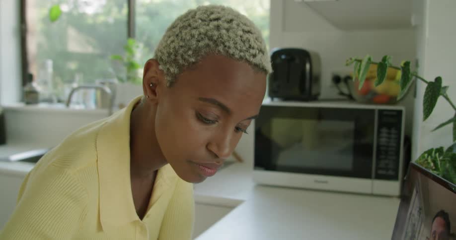 A woman is talking to a man on her laptop