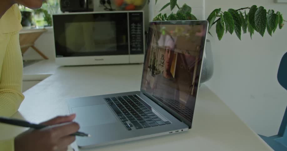 A woman is having a video conversation with someone on a laptop computer