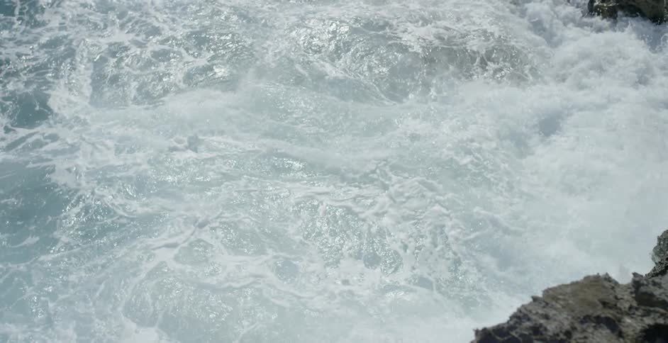 White waves crash onto a rocky area