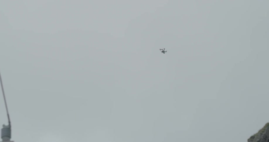 A drone flies in a cloudy sky