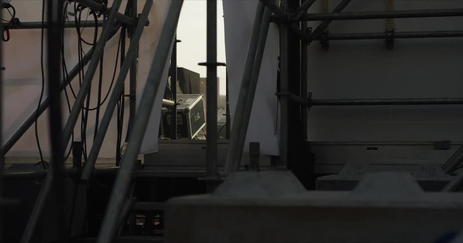 View from backstage of a musician walking around on the stage with a microphone