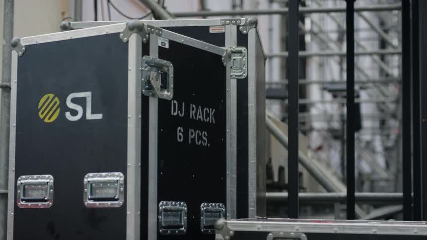 Crates next to a wall with scaffolding the sky and clouds in the background