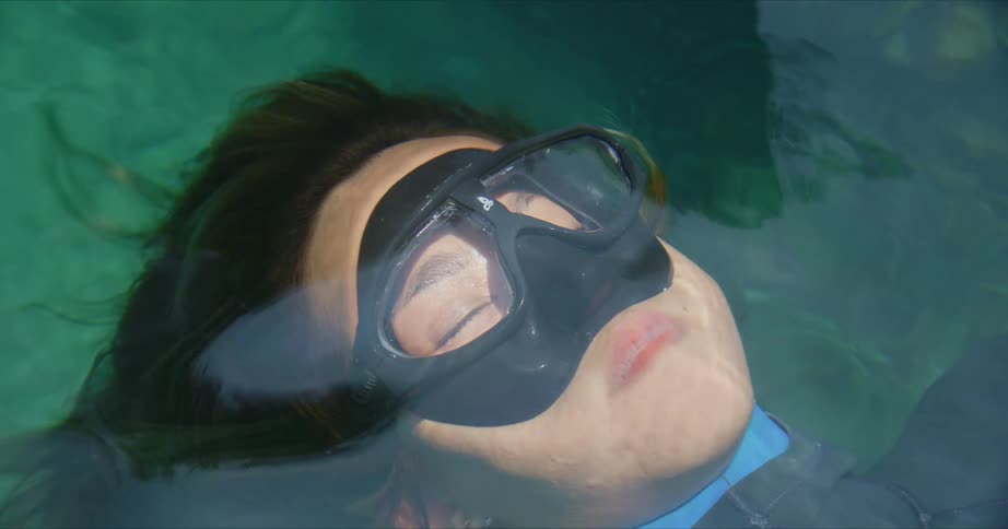 A woman with goggles underwater