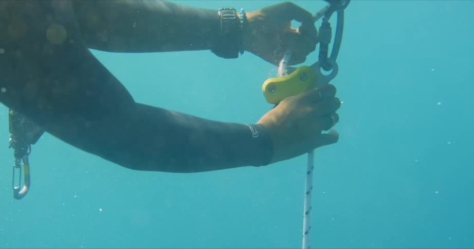 A person messing with a rope underwater