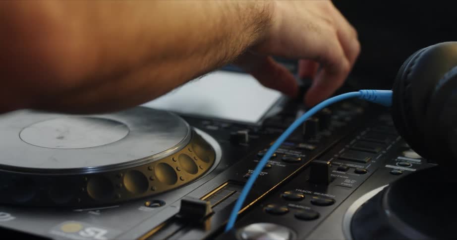 A man adjusts a dial on an audio control board
