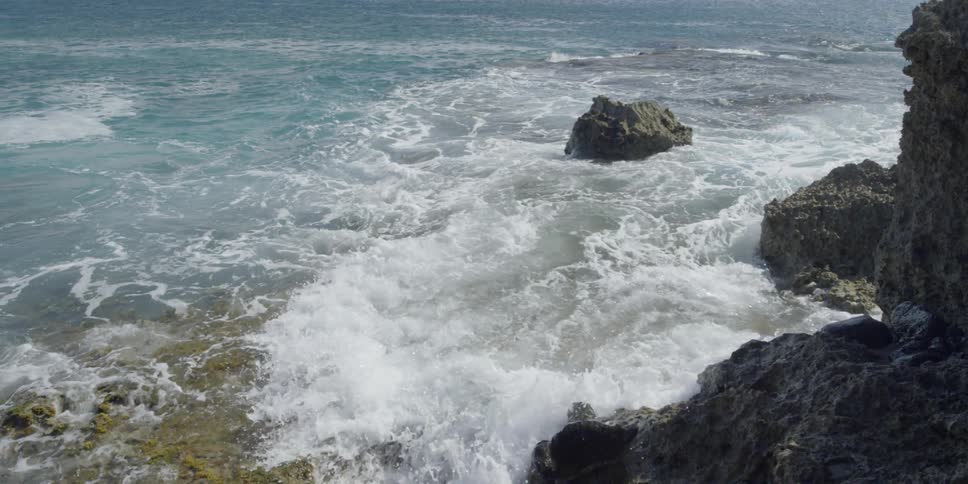 Waves crash against the rocks near the shore