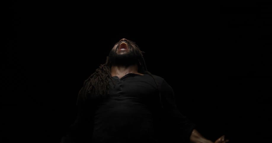 A man throws his head and arms back as he yells
