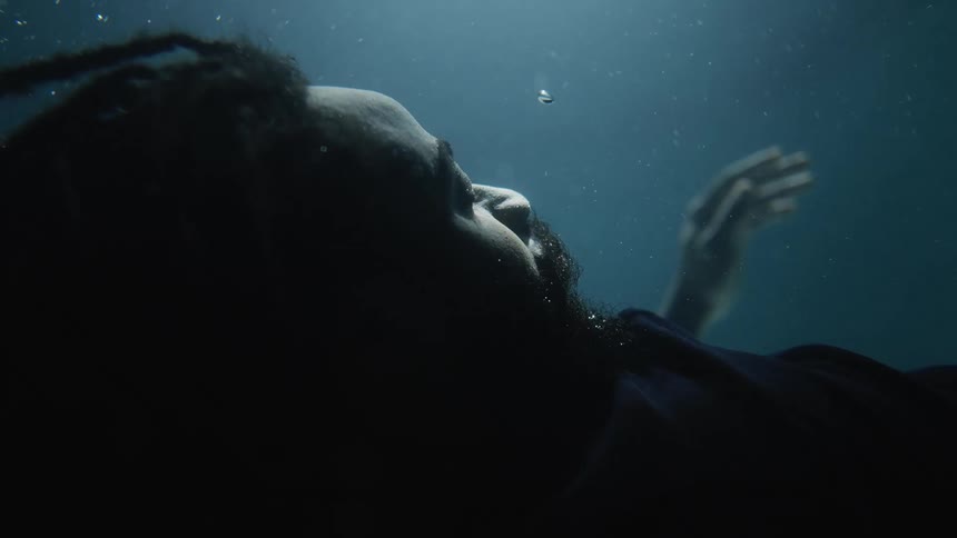 A man is underwater and bubbles are coming from his head