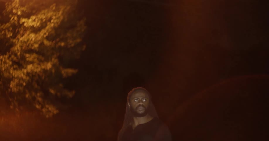 A man looks around outside at night