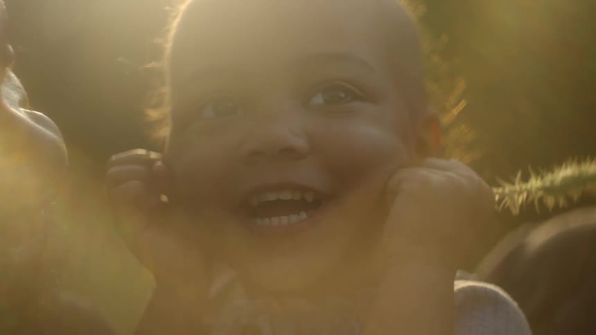 A man is holding his daughter who is holding a flower and smiling