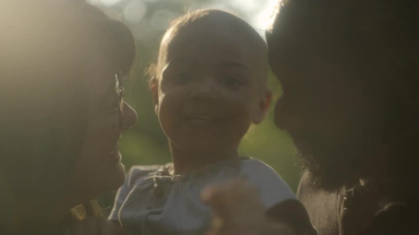 A mother father and son outside with a child
