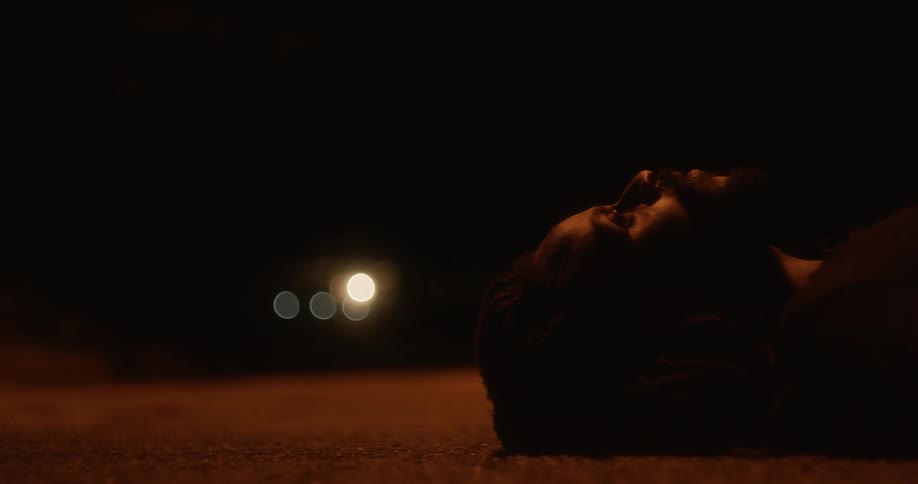 A man is laying in the street at night