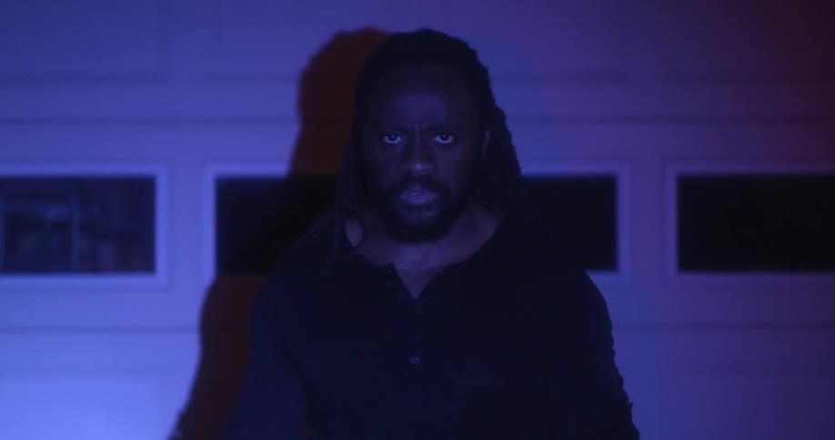 A man standing outdoors with red and blue police lights