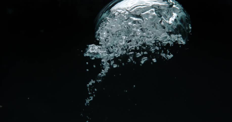 Underwater footage of a droplet of water surrounded by bubbles rising to the surface