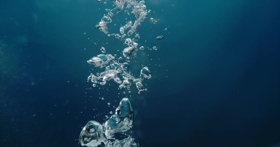 Air bubbles underwater are rising to the top