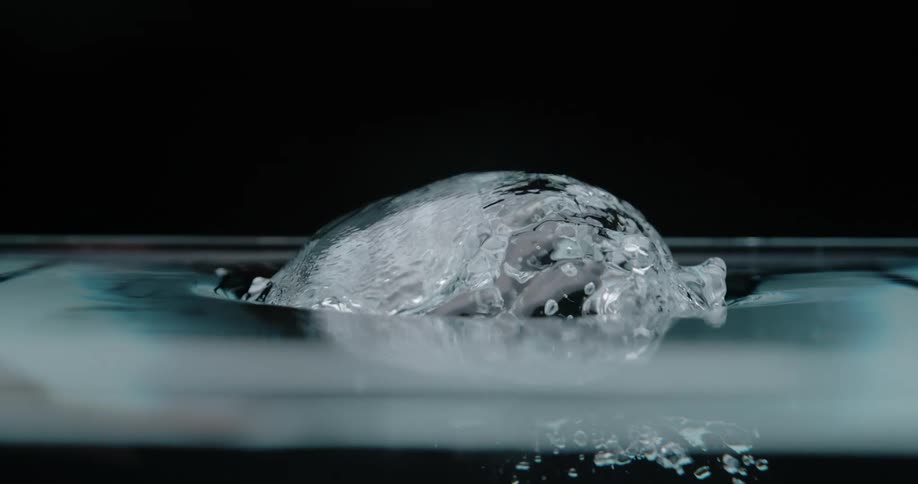Large bubbles underwater are rising to the top and up out of the water