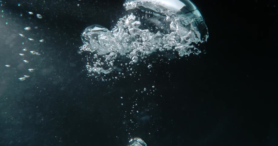Bubbles underwater are slowly rising to the top