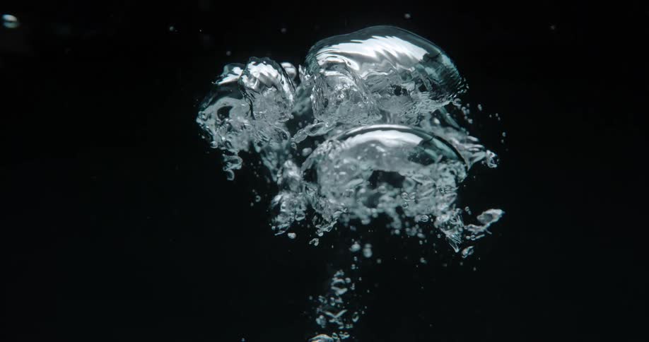 Air bubbles underwater are rising to the top