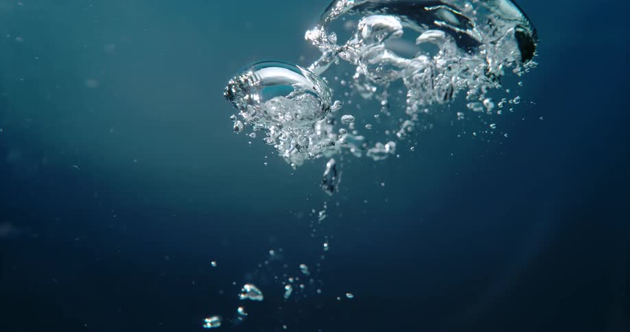 Bubbles underwater are slowly rising to the top