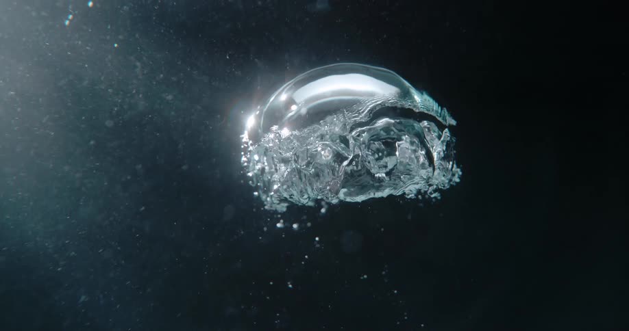 An air bubble rises to the surface of the water