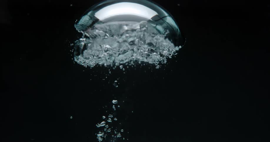 A water droplet explodes as it floats upward