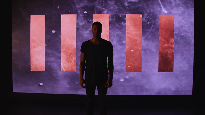 A man is standing in front of a display with art on it