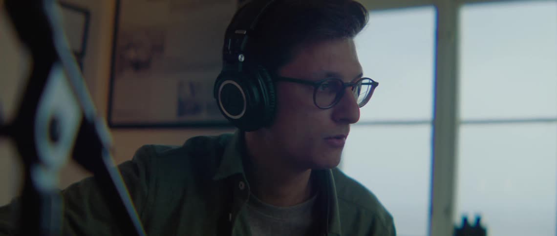 A man is wearing headphones and listening to music in a studio
