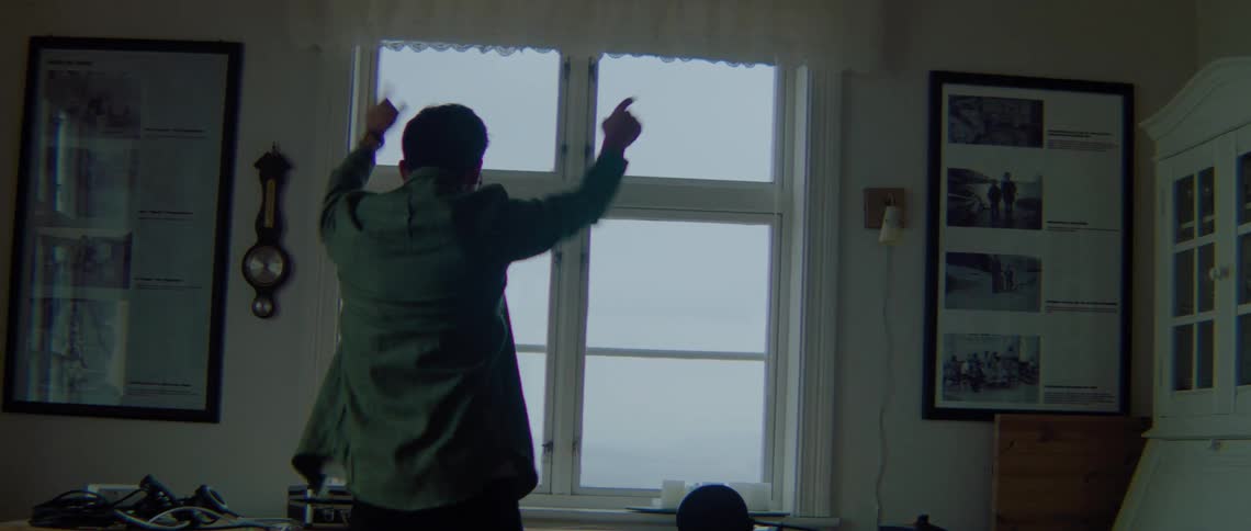 A man walks over to his desk to fix something