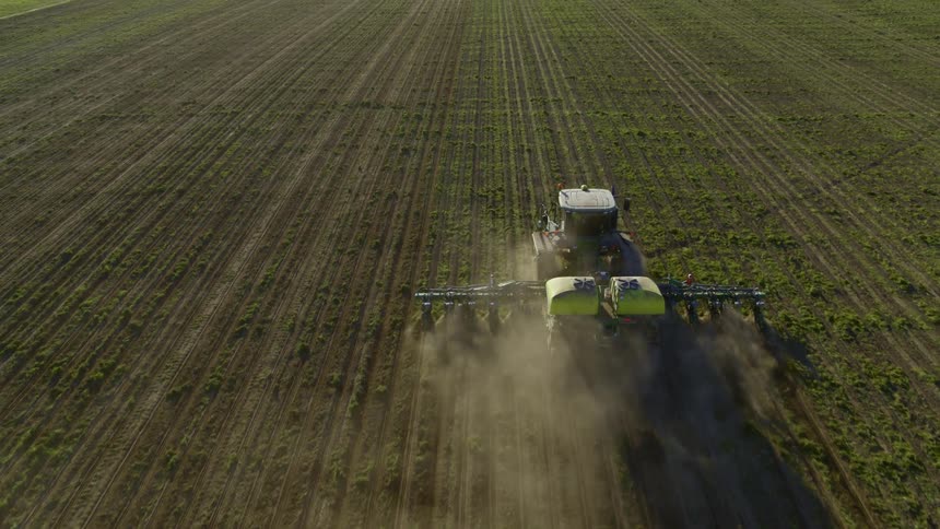 Following behind a tractor pulling a corn planter