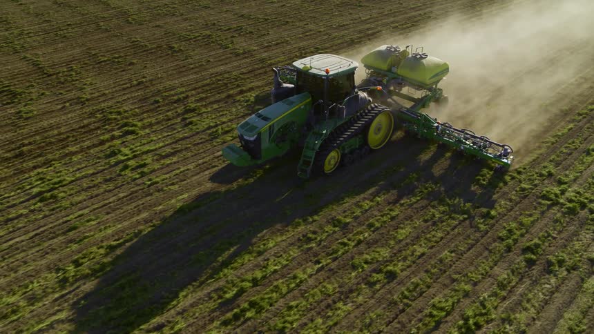 Leading a tractor with a precision planting system working at sunrise