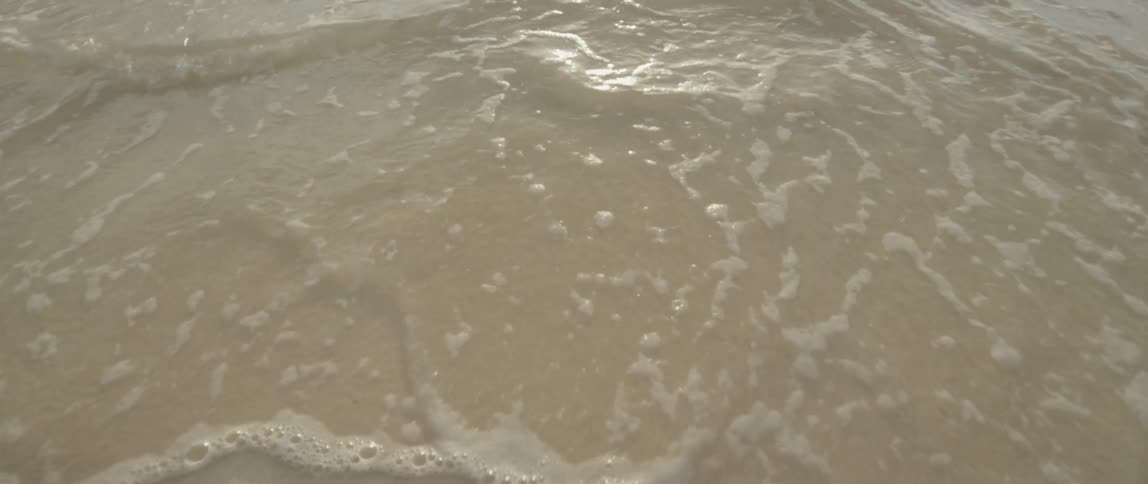 Waves slowly move over the sand