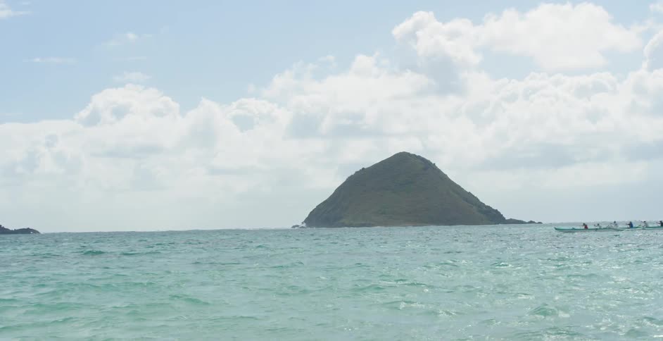 Sculling crew moving through the water with a mountain in the background