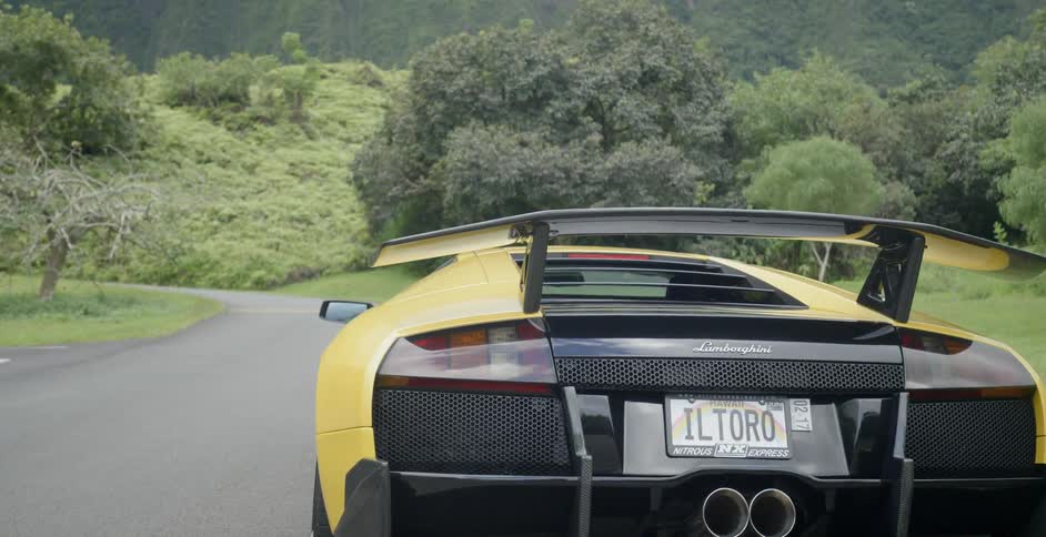 A yellow car sits on a road