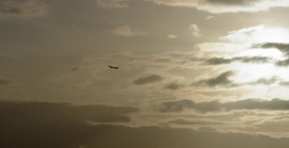 An airplane flies through the clouds in the sky