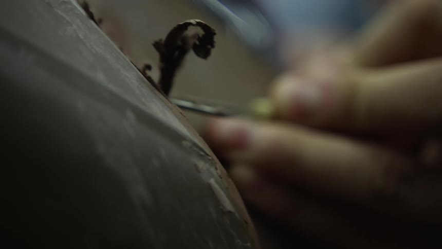 A person with a tool shaving chocolate